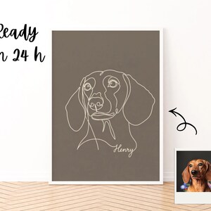 Puede incluir: Un estampado enmarcado con un dibujo lineal minimalista blanco de la cabeza de un perro salchicha sobre un fondo marrón apagado. El nombre del perro, "Henry", está escrito en cursiva debajo del dibujo. Una pequeña foto de un perro salchicha está en la esquina inferior derecha. El texto "Ready in 24 h" está en la esquina superior izquierda.