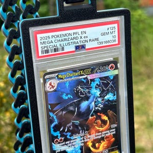 May include: A Pok&eacute;mon trading card featuring Mega Charizard X ex, graded GEM MT 10, with a special illustration. The card is encased in a protective holder with a black and blue lanyard.