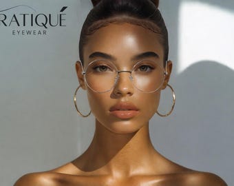 May include: A woman wearing round, gold-rimmed eyeglasses and large gold hoop earrings. The image features the text "ERATIQUE EYEWEAR" at the top left. The woman has her hair up and is looking forward.