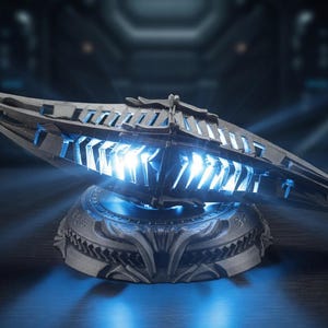 May include: A futuristic, metallic sculpture with a sleek, elongated design. The sculpture is mounted on a detailed base and emits a bright blue light from within. The overall aesthetic suggests a science fiction or fantasy theme.