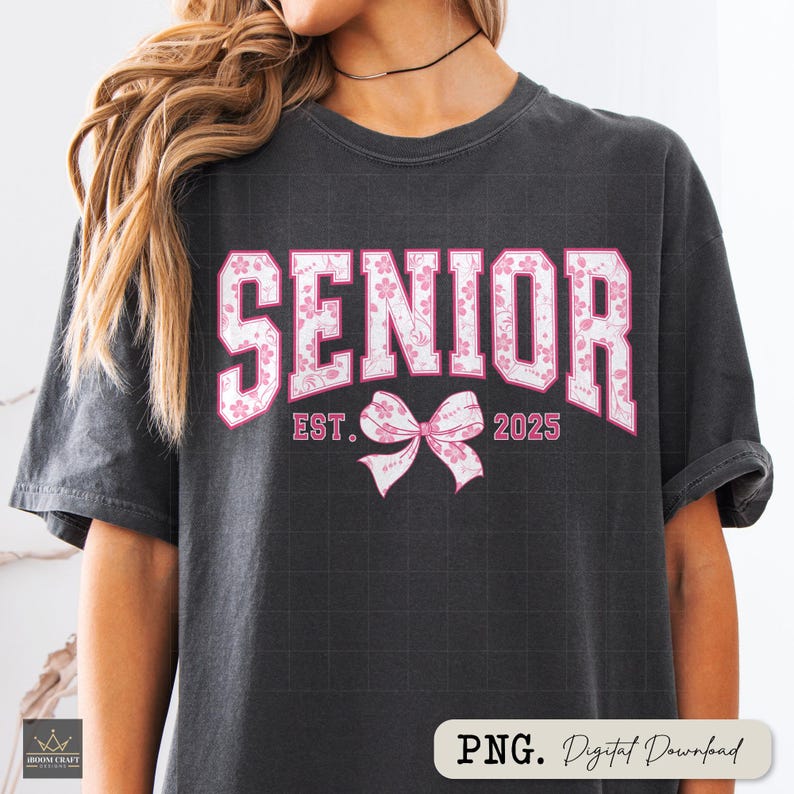 Pu&ograve; includere: T-shirt grigio scuro con la parola "SENIOR" in grandi lettere rosa a fantasia floreale. Sotto la scritta, il testo "EST. 2025" e un fiocco rosa. La maglietta &egrave; un download digitale.