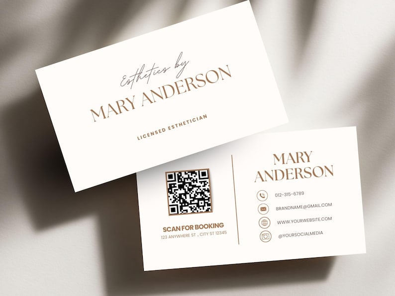 May include: Two business cards with a cream background and brown text. The top card reads "Esthetics by MARY ANDERSON, LICENSED ESTHETICIAN." The bottom card includes contact information, a QR code, and the text "SCAN FOR BOOKING 123 ANYWHERE ST, CITY ST 12345."