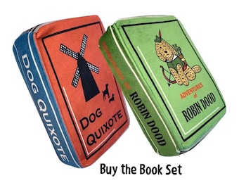 May include: Two plush book-shaped pillows, one red with a windmill and the text "Dog Quixote", the other green with a dog in a green outfit and the text "Adventures of Robin Dood".