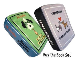 May include: Two plush book-shaped toys with the titles "Hairy Petter" and "Romeo and Drooliet" by J.K. Growling and Shakesbear. The toys are blue and gray with colorful illustrations.