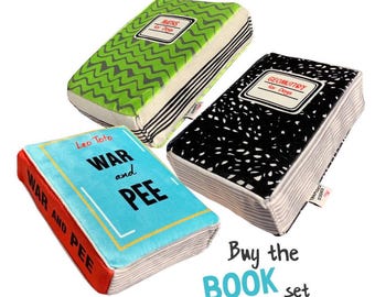 May include: Three plush dog toys shaped like books. One is green with a zig-zag pattern and the text "MATHS for Dogs". Another is black with white speckles and the text "GEOMUTTRY for Dogs". The third is blue with the text "WAR and PEE".