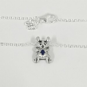 May include: A white ceramic mug with a black handle and the text "But First, Coffee" in a black, bold font. The mug is on a white surface. The mug is approximately 10 cm tall.