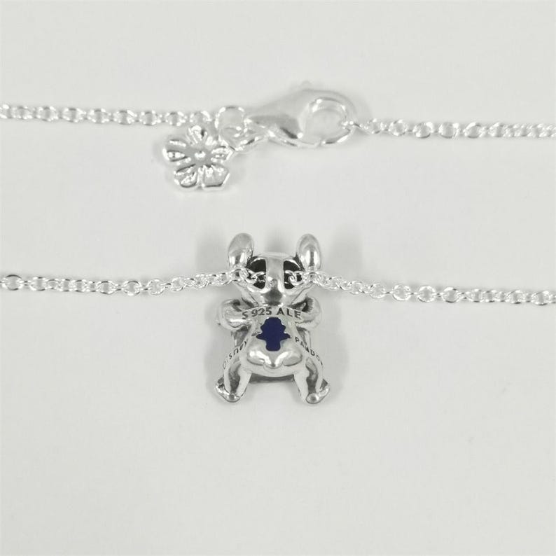 May include: A white ceramic mug with a black handle and the text "But First, Coffee" in a black, bold font. The mug is on a white surface. The mug is approximately 10 cm tall.