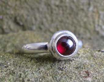 Silver ring with a Garnet cabochon in an organic silver mount.