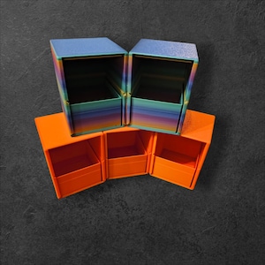May include: A collection of colorful storage boxes. Two boxes are blue with rainbow-colored sides, and three are orange. The boxes are arranged in a visually appealing display, perfect for organizing small items.