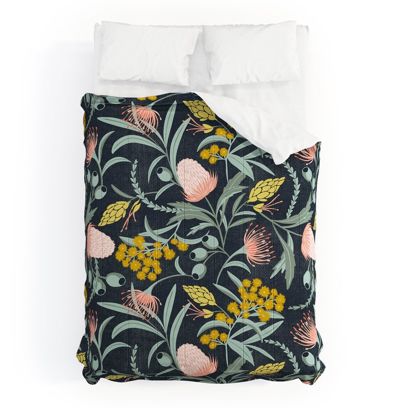 May include: A navy blue quilt with a floral pattern featuring pink and yellow flowers, green leaves, and small yellow berries.