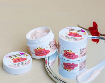 May include: White jars of Daylight Dew Hydration Cream are displayed on a reflective surface. One jar is open, revealing a pink cream. The labels feature the text "Ayurveda Apothecary Co." and "Daylight Dew Hydration Cream."