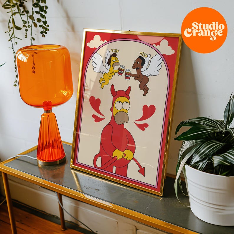 K&ouml;nnte beinhalten: Ein gerahmter Druck mit einer Cartoon-Illustration eines teuflischen Homer Simpson mit zwei Engeln dar&uuml;ber. Der Druck hat einen goldenen Rahmen und einen rosa und wei&szlig;en Hintergrund. Der Text "Studio Orange" ist in der oberen rechten Ecke des Bildes sichtbar.