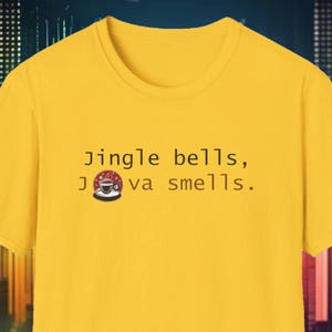 Op de afbeelding: Geel T-shirt met de tekst "Jingle bells, Java smells." en een cartoon afbeelding van een kopje koffie.