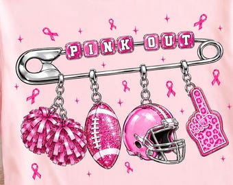 Könnte beinhalten: Ein hellrosa T-Shirt mit einer großen silbernen Sicherheitsnadel-Grafik und dem Text PINK OUT. An der Nadel hängen vier Anhänger: zwei rosa Pompons, ein glitzernder Football, ein rosa Football-Helm und ein rosa Schaumstofffinger mit Leopardenmuster.
