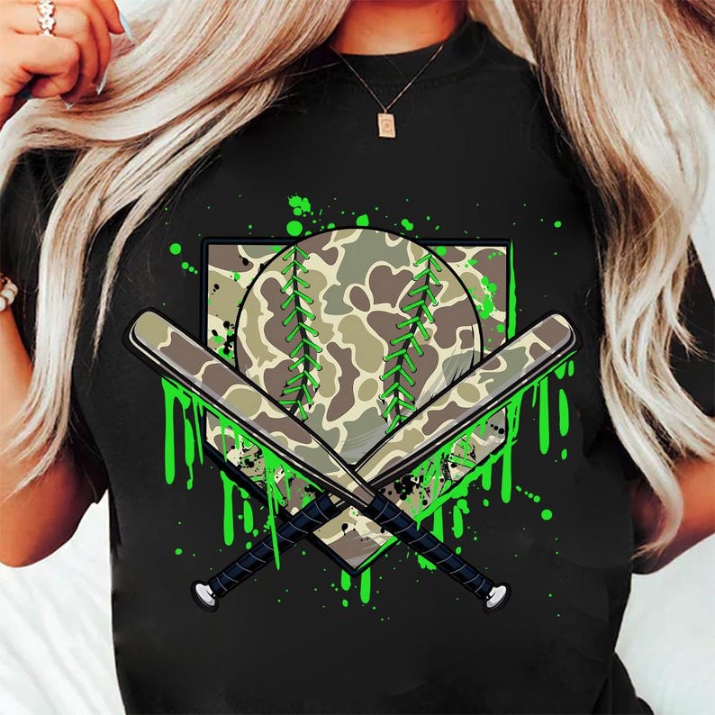 May include: Black t-shirt featuring a green camouflage baseball, two crossed bats, and green paint splatters.