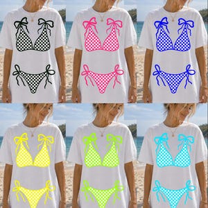 May include: White t-shirts with bikini designs in black and white, pink, blue, yellow, green, and turquoise checkered patterns. Each design includes a bikini top and matching bottoms, perfect for summer.