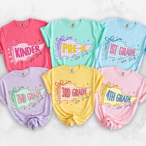 May include: Six short-sleeved t-shirts in pink, mint green, light blue, lavender, yellow, and light pink. Each shirt features a pennant graphic with a gingham pattern and text including Kinder, Pre-K, 1st Grade, 2nd Grade, 3rd Grade, 4th Grade, and Mrs. Smith.