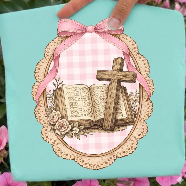May include: A light blue decorative pillow featuring a pink and white gingham pattern, a wooden cross, and an open book. The design includes a pink bow and a floral border, creating a religious theme.