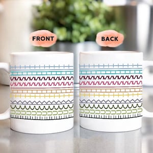 Op de afbeelding: Twee witte keramische mokken met een kleurrijk geometrisch patroon. Het ontwerp bevat horizontale banden in verschillende kleuren en vormen, waaronder lijnen, zigzags en curven. De woorden "FRONT" en "BACK" zijn zichtbaar.