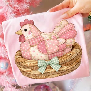 May include: A pink fabric hen with patchwork patterns of polka dots, gingham, and floral designs sits in a woven basket. The hen has a red comb and wattle, a yellow beak, and a green gingham bow.