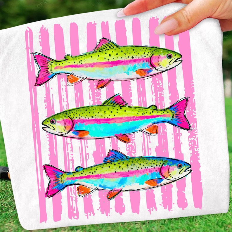 May include: White towel featuring three colorful rainbow trout illustrations. The fish have green backs, pink and blue stripes, and bright pink fins. The background has vertical pink stripes.
