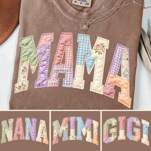 Pode incluir: Uma camisola castanha com a palavra "MAMA" aplicada na frente em um design de patchwork. As letras são em estilo universitário, com cada letra apresentando um tecido floral ou estampado diferente. Um colar de prata com um pingente é visível.