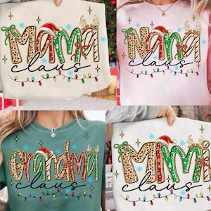 Puede incluir: Cuatro sudaderas navideñas. Las sudaderas son crema, rosa, verde y blanca. Cada sudadera tiene un nombre diferente: Mama, Nana, Grandma y Mimi, con un gorro de Papá Noel y cuernos de reno. La palabra "Claus" está escrita debajo.