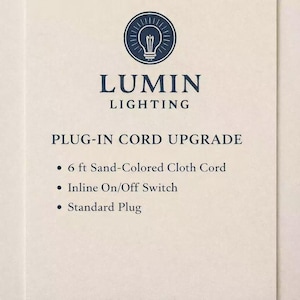 May include: Cream-colored card with the Lumin Lighting logo, a lightbulb design inside a circle. Text reads "Plug-In Cord Upgrade" with bullet points listing features: 6 ft sand-colored cloth cord, inline on/off switch, and standard plug.