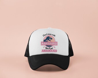 May include: A black and white trucker hat with the text "Don't mess with Mamasaurus You'll get Jurasskicked" in pink and blue. The hat has a white front panel and a black brim and mesh back.