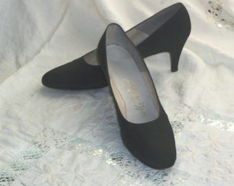 May include: A pair of black suede heeled pumps with a pointed toe.
