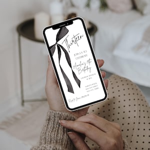 May include: A smartphone displays a black and white invitation for Amelia's 13th birthday. The design features the word "Thirteen" in elegant script, a bow graphic, and event details. The phone is held in a person's hands.
