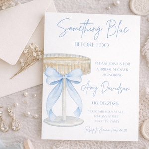 Op de afbeelding: Een lichtblauwe bruidsdouche-uitnodiging met de tekst "Something Blue Before I Do". De uitnodiging bevat een aquarel illustratie van een taartstandaard met een blauwe strik. De uitnodiging bevat de naam Amy Davidson en de datum 06.06.2026.