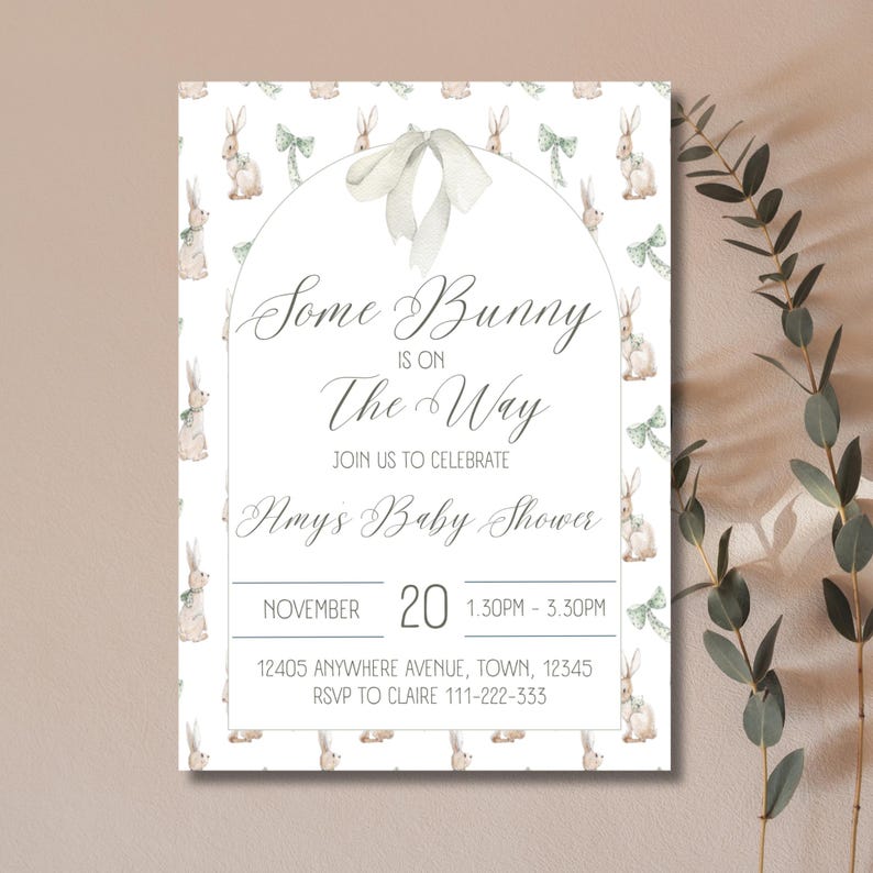 Op de afbeelding: Een witte babyshower-uitnodiging met een groen en bruin konijnenpatroon. De tekst luidt "Some Bunny is on The Way" met een datum en tijd voor het evenement. De uitnodiging bevat ook het adres en RSVP-informatie.