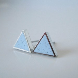 Puede incluir: Un par de pendientes de botón triangulares de plata con un acabado azul claro moteado.