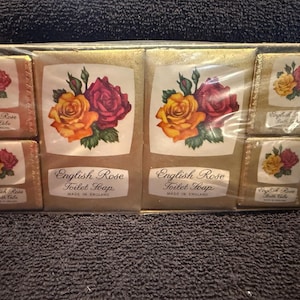 May include: A set of six vintage English Rose bath and toilet soaps. The soaps are wrapped in gold foil and feature a rose design. The text on the soaps reads "English Rose Bath Tube" and "English Rose Toilet Soap Made in England."