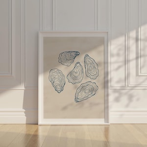 May include: A framed art print featuring a beige background with six blue outline illustrations of oysters. The artwork is displayed against a white wall with decorative molding, and natural light casts shadows across the scene.