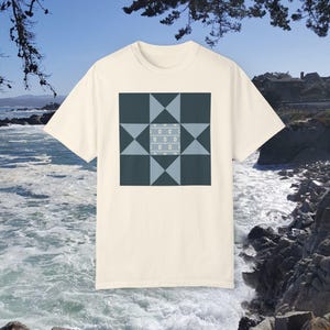 Peut inclure: Un t-shirt crème avec un motif d'étoile géométrique bleu et blanc imprimé sur le devant.