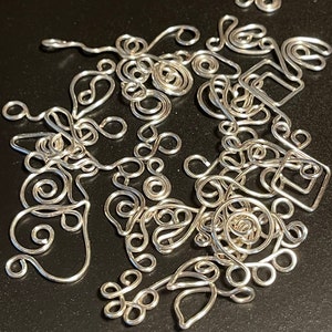 Peut inclure: Un ensemble de trouvailles de bijoux en fil d'argent, comprenant des boucles, des volutes et des feuilles. Ces trouvailles sont parfaites pour créer des boucles d'oreilles, des colliers et des bracelets.