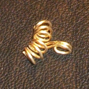 May include: A gold-colored wire ear cuff with a spiral design.