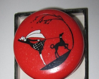 Porta-comprimidos vintage dos anos 70 em baquelite, modelo "A Senhora Passeando com o Cachorro", da Sarsaparilla Deco Design, na cor vermelho cereja.