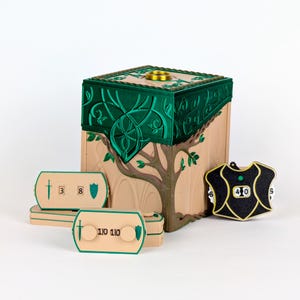 May include: A beige and green cubic game box featuring an embossed tree design, accompanied by three beige rectangular score trackers with sword and shield icons, and one black shield-shaped life counter with gold trim.