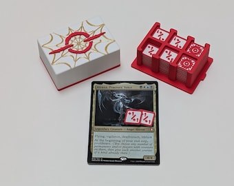 Può includere: Una scatola bianca e rossa con un design dorato, un porta carte rosso con più carte e una carta Magic: The Gathering. La carta presenta il testo "Atraxa, Praetors' Voice" e ha due dadi.