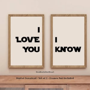 May include: A set of two vertical wall art prints in light wood frames. The left print features the black text I LOVE YOU, and the right print features the black text I KNOW. The background of each print is a solid light beige colour.