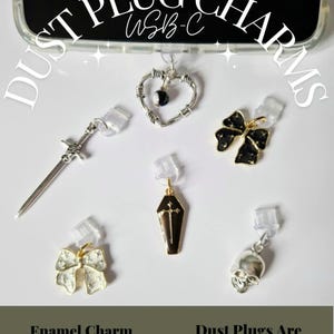 May include: A selection of USB-C dust plug charms featuring a sword, heart, bow, coffin, and skull designs. The charms are in silver, gold, and black, with enamel detailing. The image text reads "Dust Plug Charms" and "Enamel Charm USB-C".