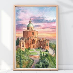 Puede incluir: Pintura a la acuarela del Santuario de la Madonna di San Luca en Bolonia, Italia, sobre un cielo de atardecer. La obra presenta la arquitectura del edificio, una cúpula verde y vegetación circundante, enmarcada en madera clara.