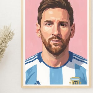 Puede incluir: Retrato enmarcado de un hombre con cabello castaño y barba, vistiendo una camiseta a rayas azules y blancas. El fondo es de color rosa sólido. El retrato está en un marco de madera clara.