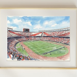 Puede incluir: Pintura a la acuarela de un estadio de fútbol con un campo verde y una pista de atletismo roja. Las gradas están llenas de espectadores. El cielo es azul con nubes blancas. La obra está enmarcada.