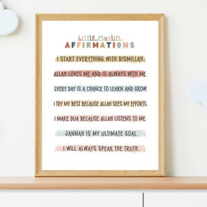 May include: A printable poster with a light brown wooden frame. The poster has a white background with colorful text that reads "Little Muslim Affirmations". The text is in a playful font and is surrounded by colorful lines. The affirmations are: "I start everything with Bismillah", "Allah loves me and is always with me", "Every day is a chance to learn and grow", "I try my best because Allah sees my efforts", "I make dua because Allah listens to me", "Jannah is my ultimate goal", and "I will always speak the truth".