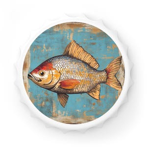 May include: A white bottle cap with a blue and brown background and a detailed illustration of a fish with orange and yellow accents.