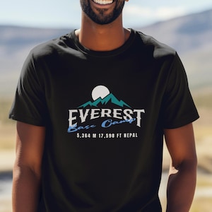 Puede incluir: Camiseta negra con un gráfico de una cordillera y el texto "EVEREST Base Camp 5.364 M 17.598 FT NEPAL"